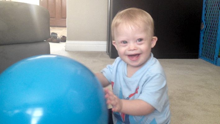 down syndrome baby pushing ball on floor