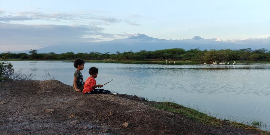 kids sitting by the river in tanzania