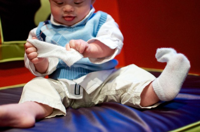 baby-pulling-socks-off-down-syndrome-fao-schwarz-nyc