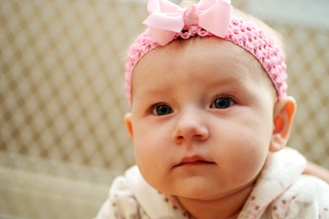 cute baby girl pink bow first kiss