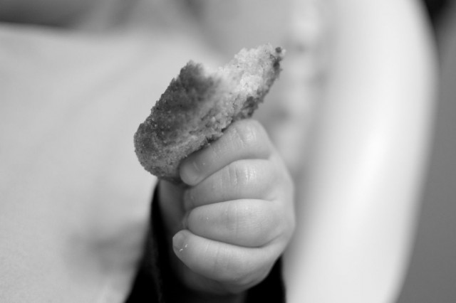baby holding toast black white