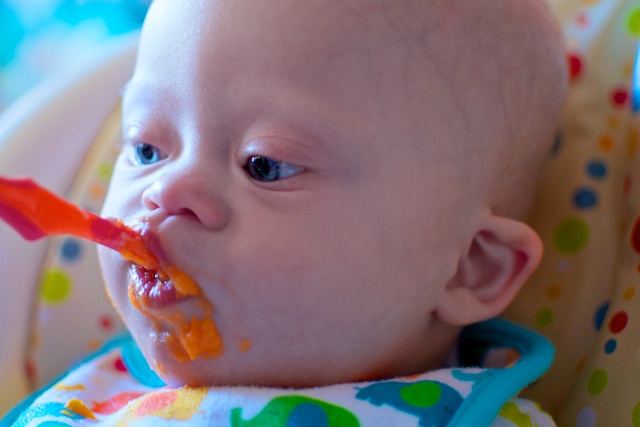 a picture of our baby born with down syndrome eating yams