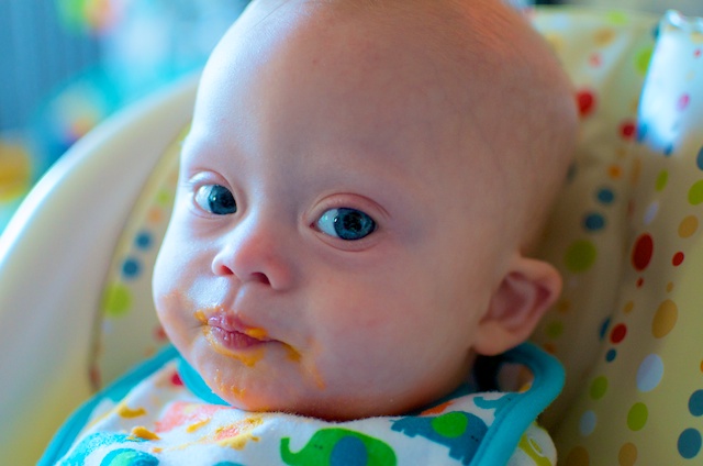 picture of our baby with down syndrome eating yams