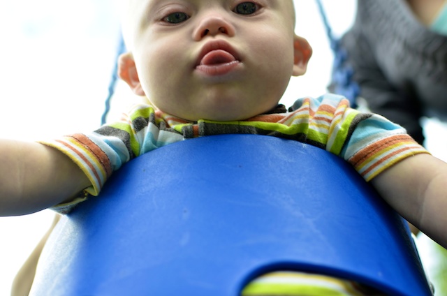 downs syndrome down boy sitting swing