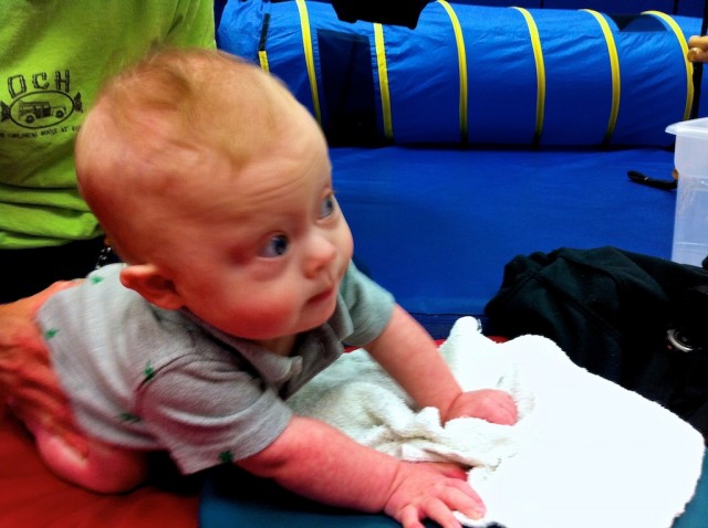 boy with down syndrome learning to crawl at physical therapy