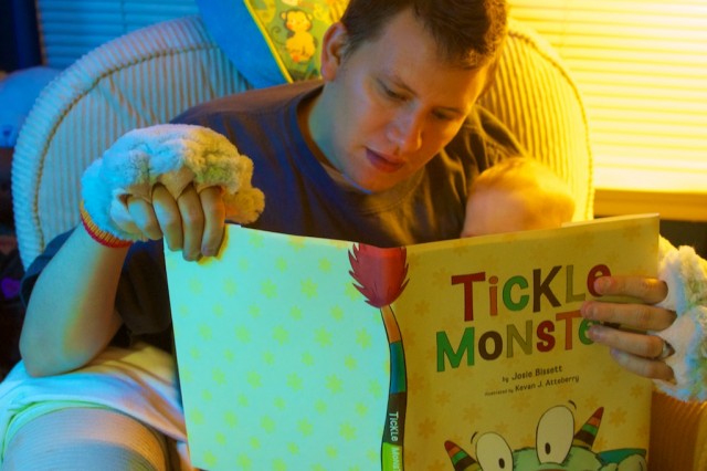 Father reading to his newborn born with downs syndrome down