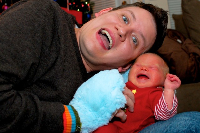 dad tickling his crying son born with Down syndrome