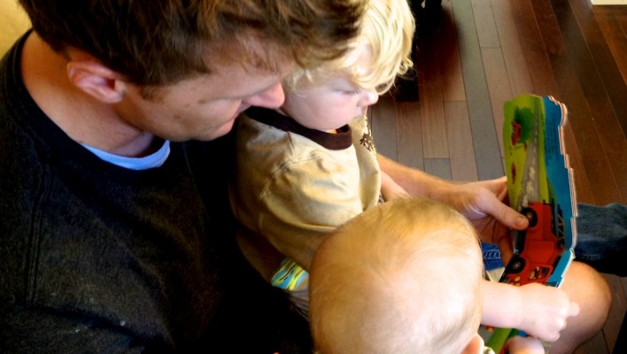 father reading story book to his children