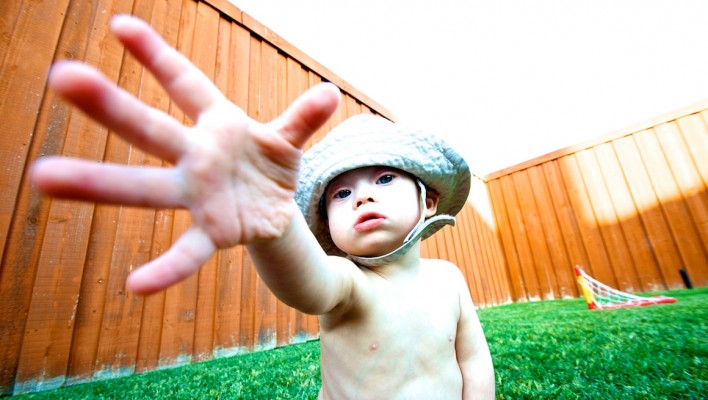 fisherman hat down syndrome child outside playing grass