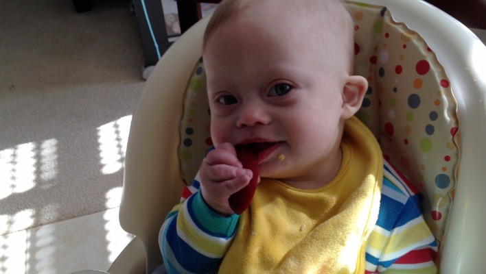 baby down syndrome self feeding with apple