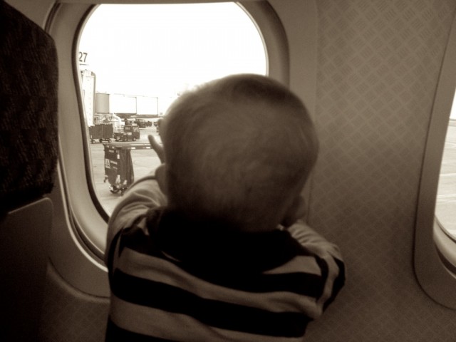 baby boy with down syndrome looking through airplane window