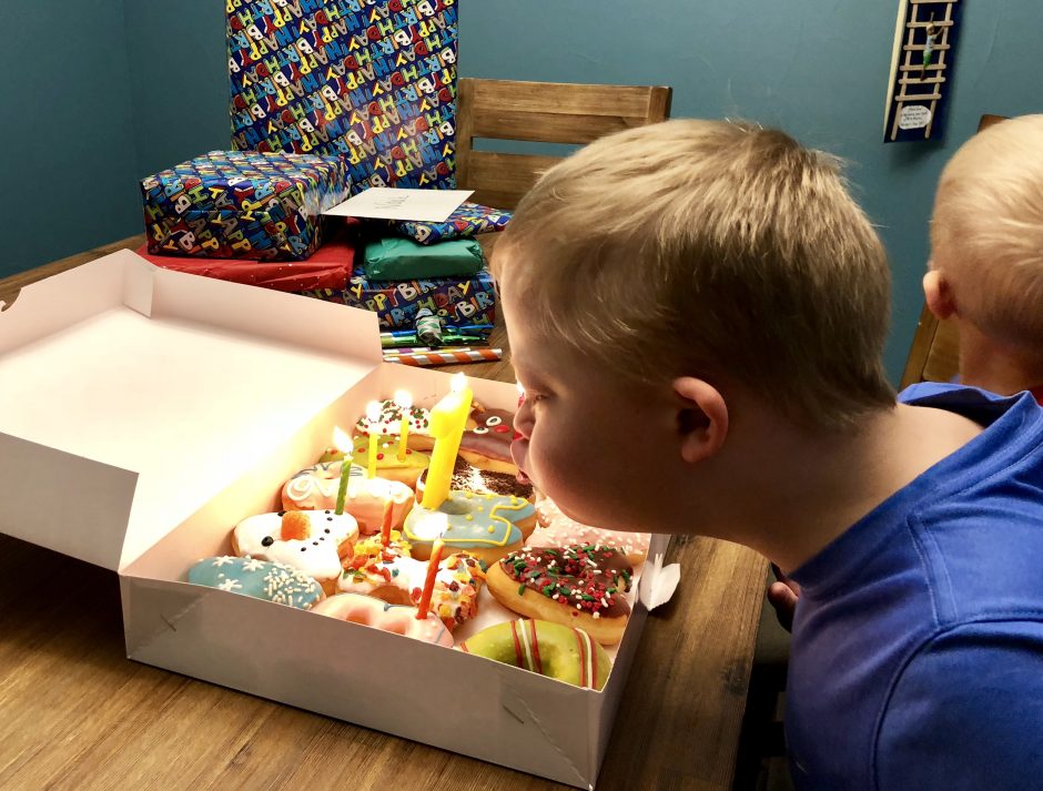 boy with down syndrome blowing out birthday candles